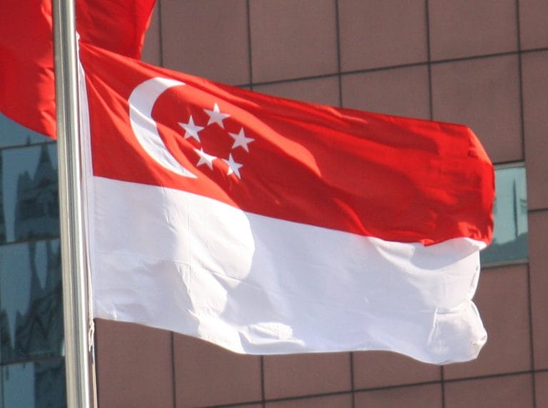 Waving national flag of Singapore on a flag pole by the best supplier, Brooklynz Singapore