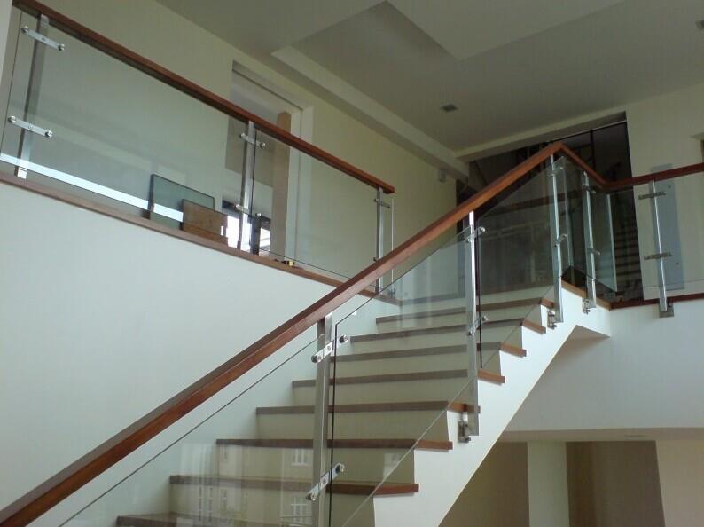 Unique glass railing with timber handrail of an interior staircase designed by Brooklynz Singapore
