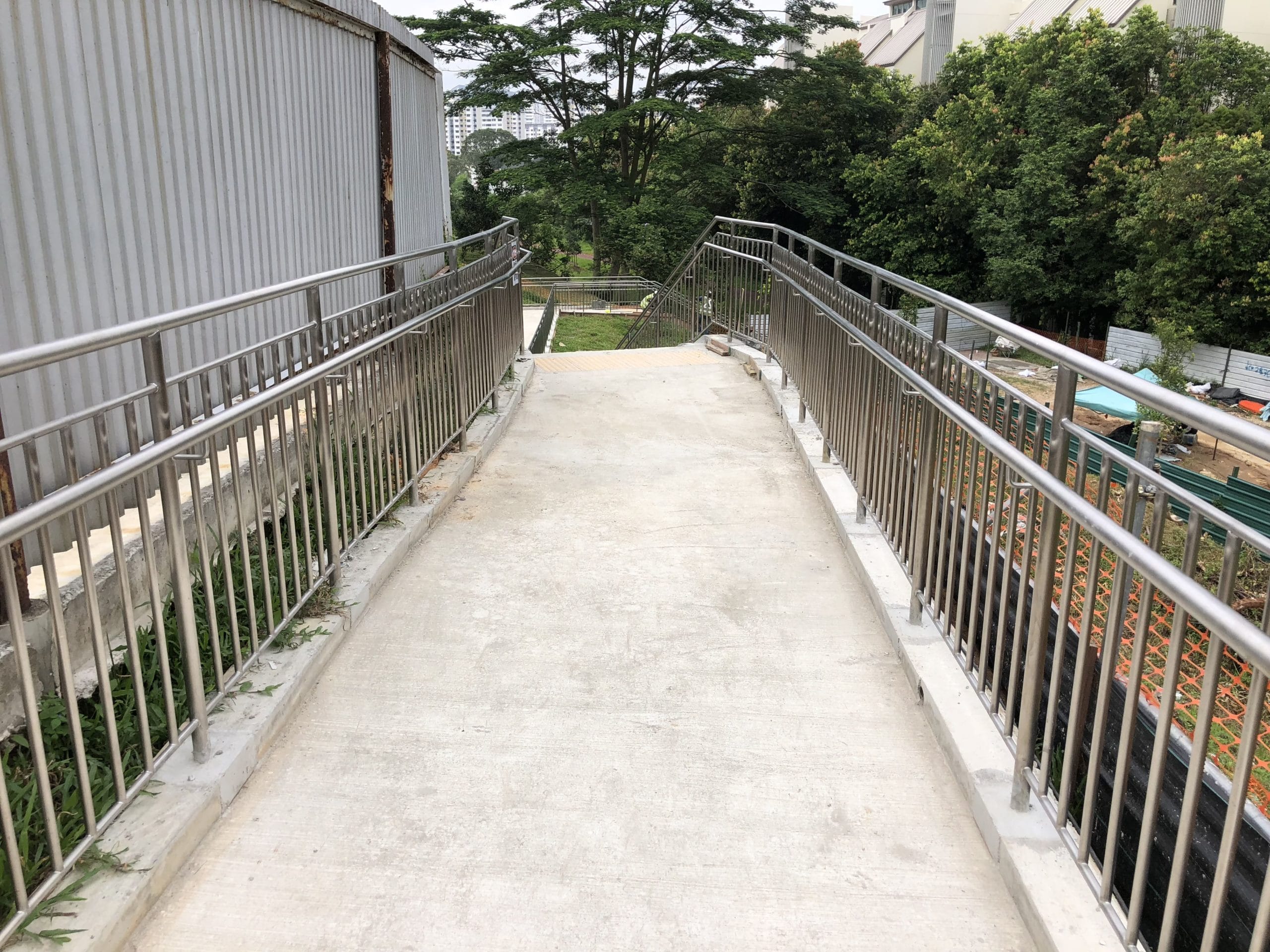 Well constructed stainless steel metal railing along a concrete pathway situated in a park by Brooklynz Singapore
