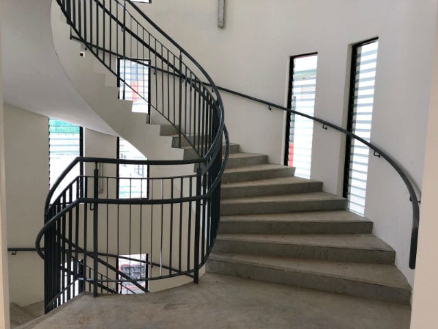 Classic black metal railings sliding across a spiral staircase in a building in Singapore